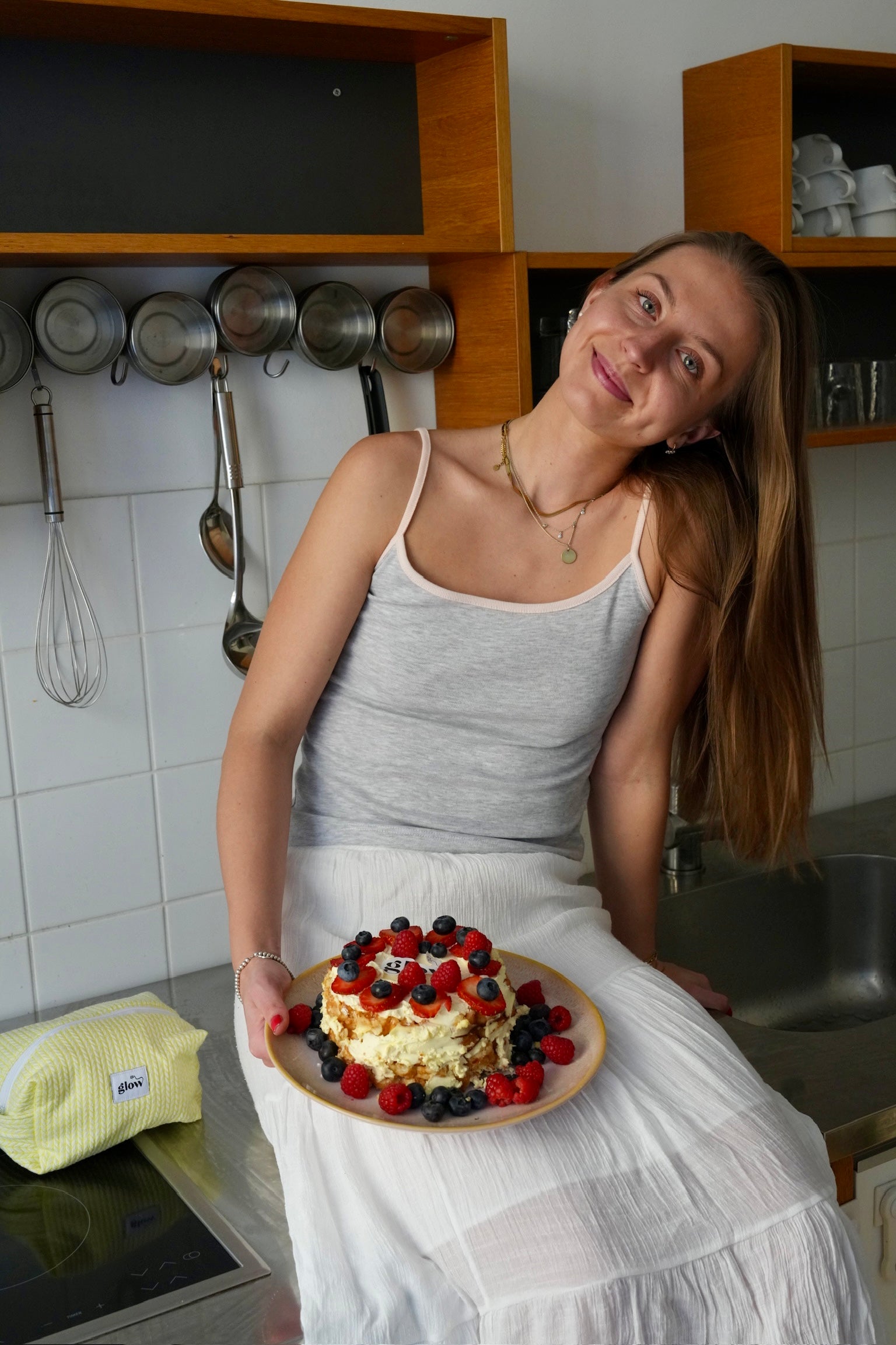 Woman holding a cake in a kitchen